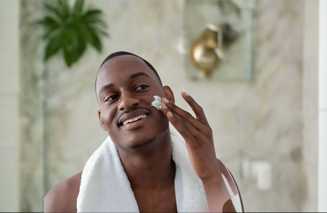 Man applying cream to his face in front of a mirror